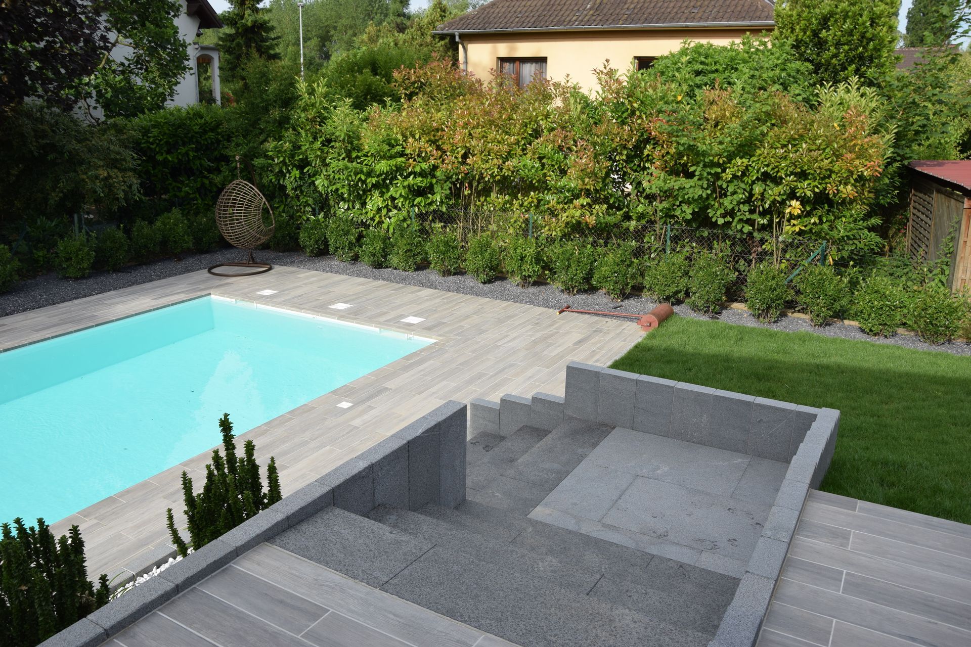 Escaliers en béton menant à une terrasse avec piscine.