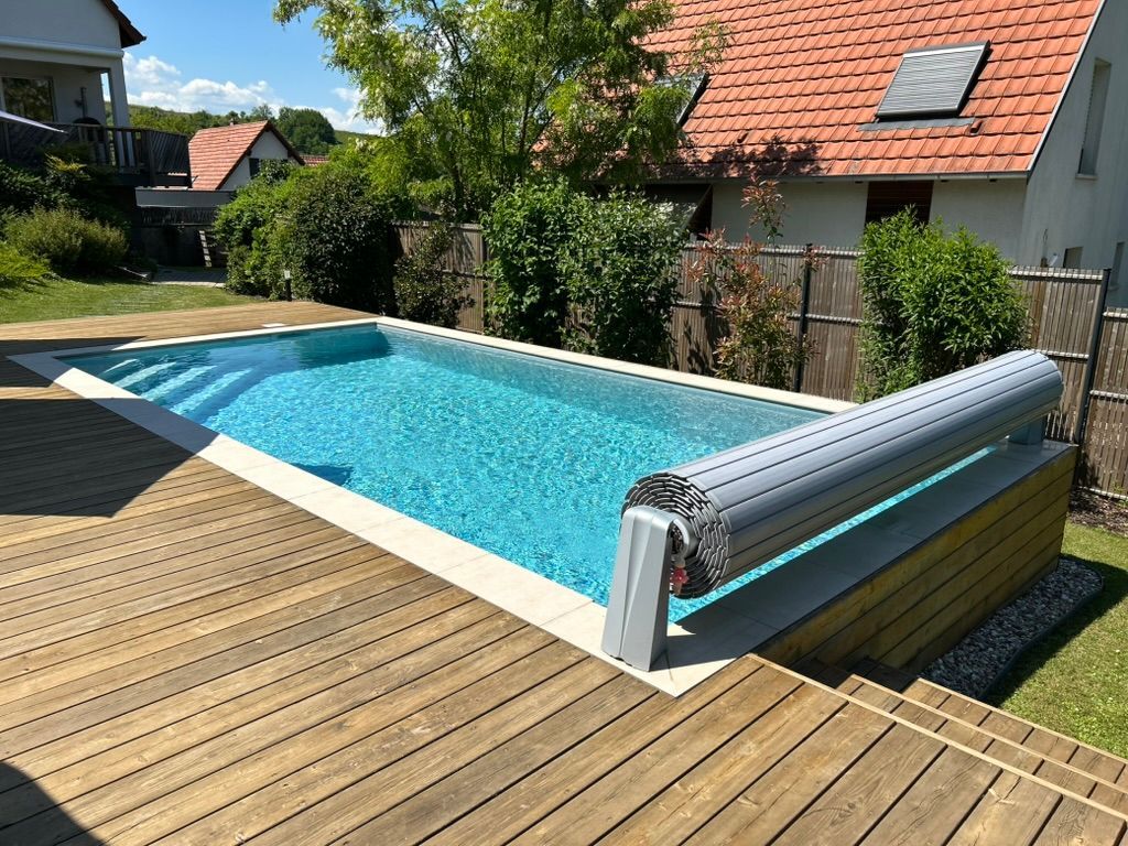 Piscine d'une terrasse en bois avec volet roulant.