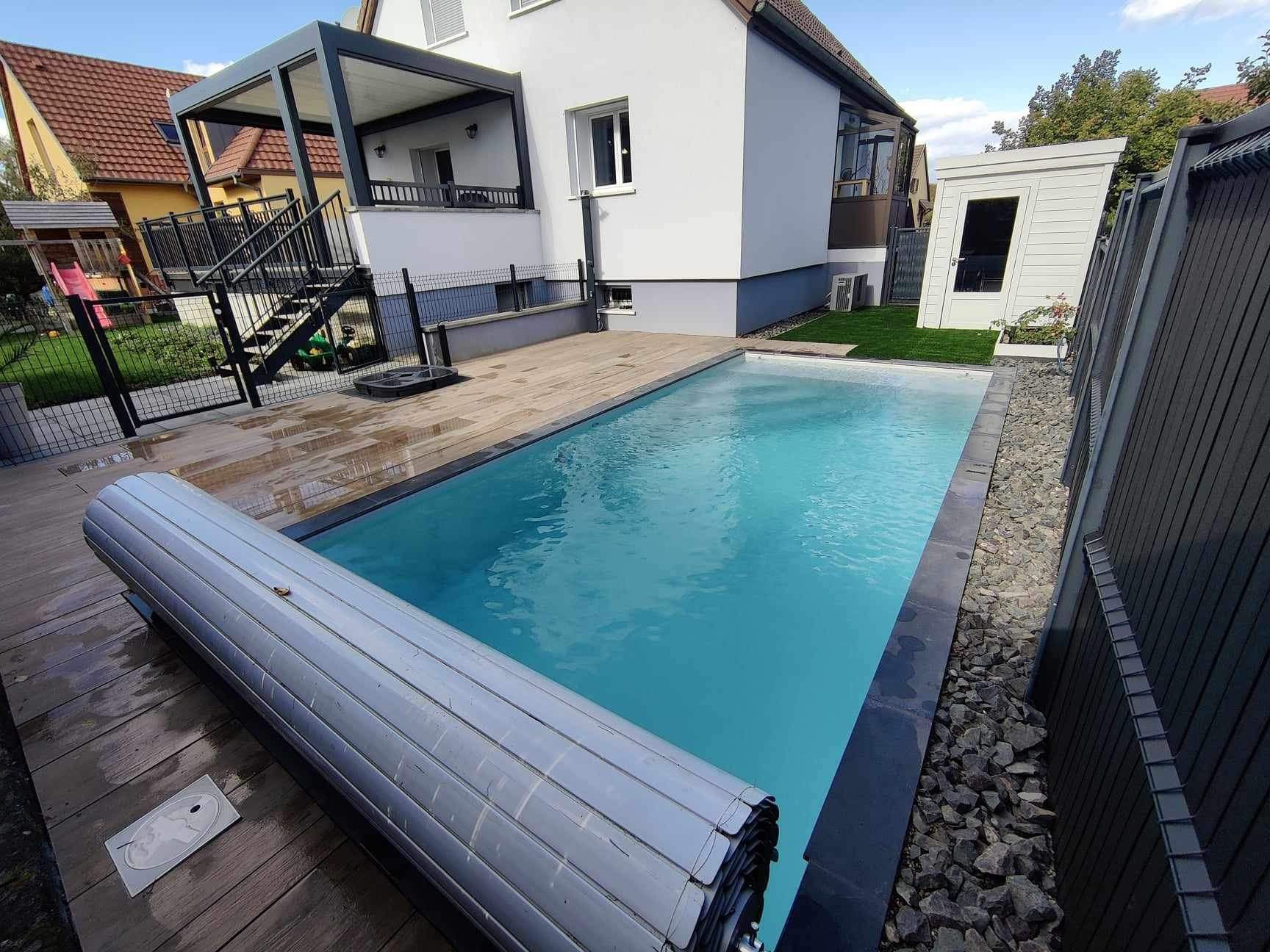 Piscine d'une petite maison à proximité d'une clôture.