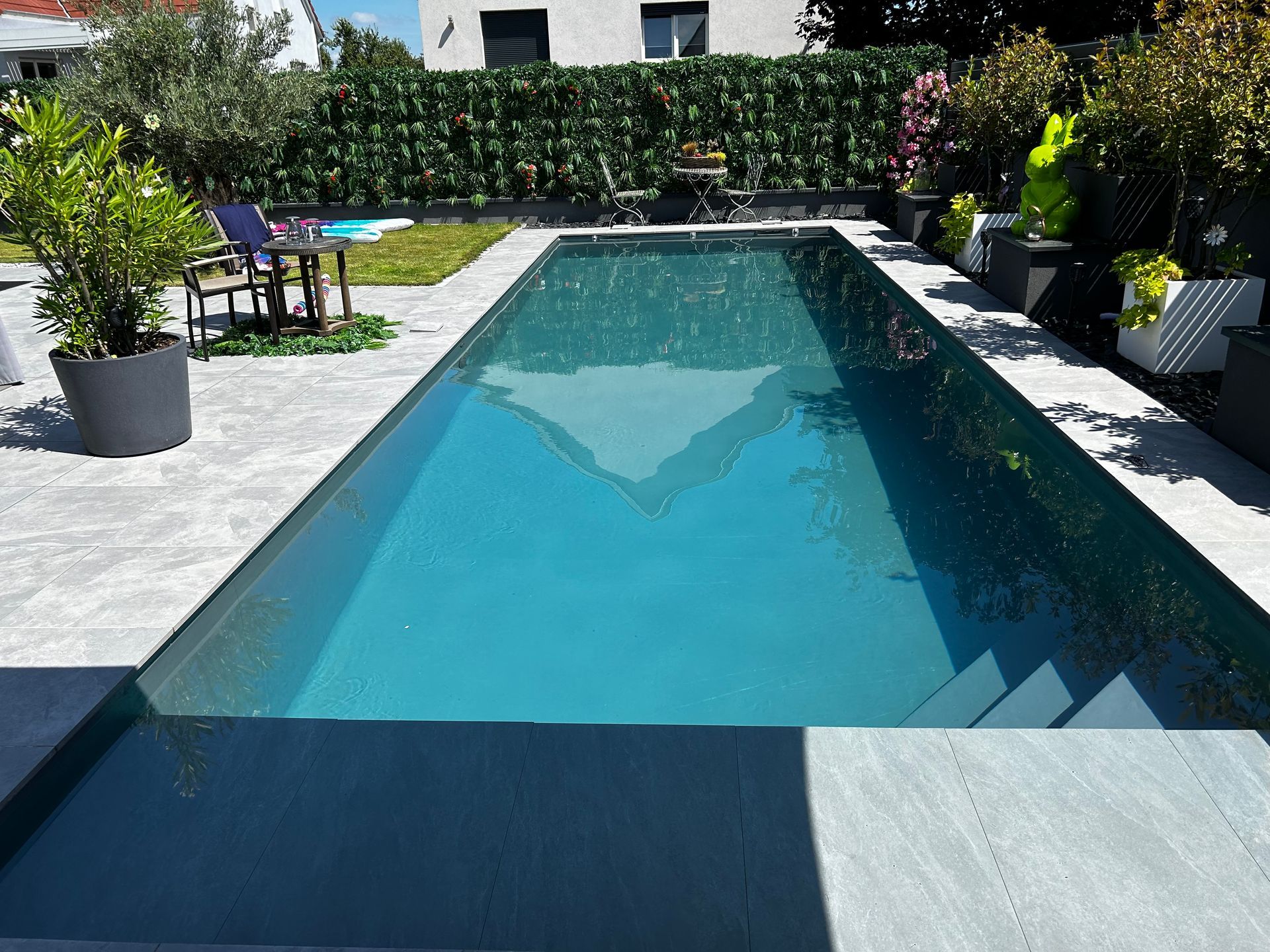 Piscine urbaine avec haies et décorations.