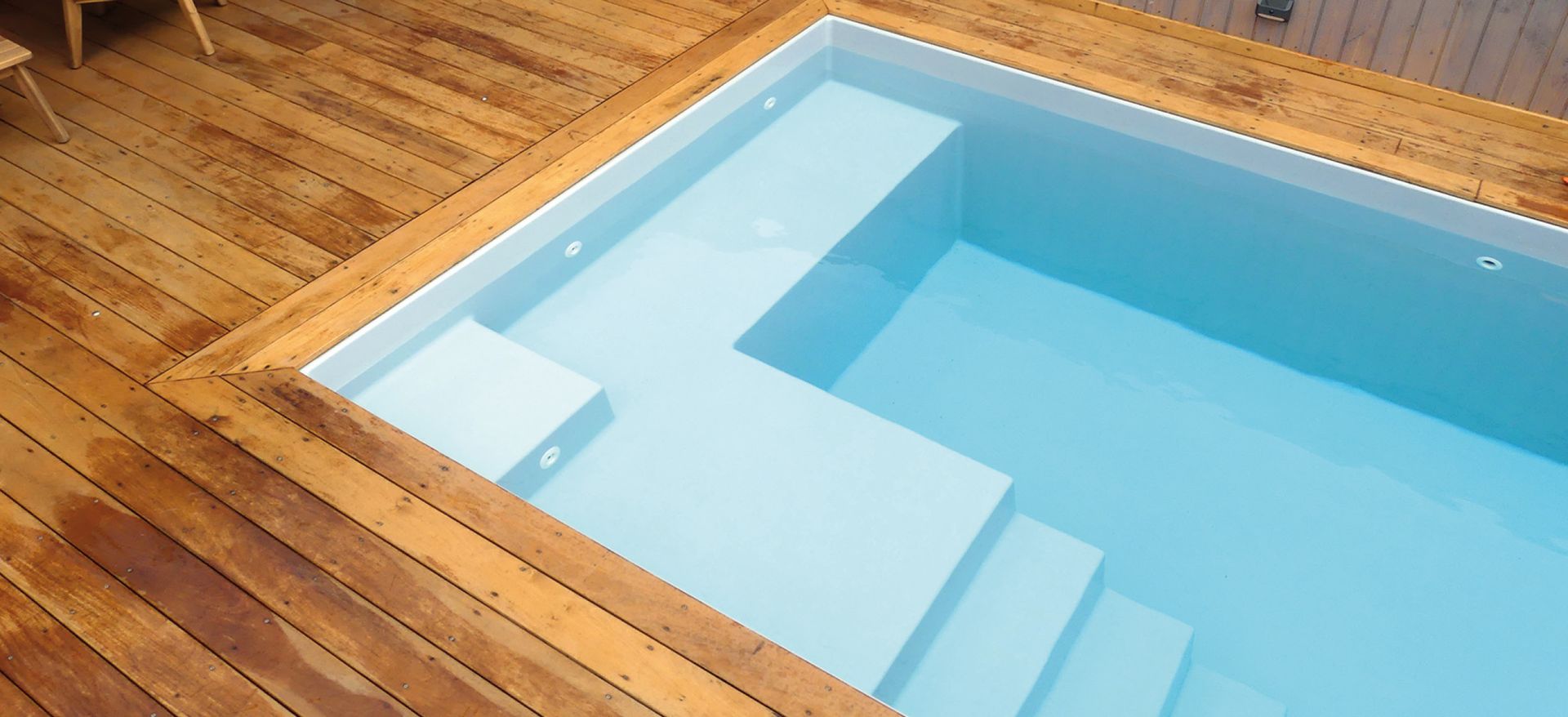 Piscine à coque avec terrasse en bois.