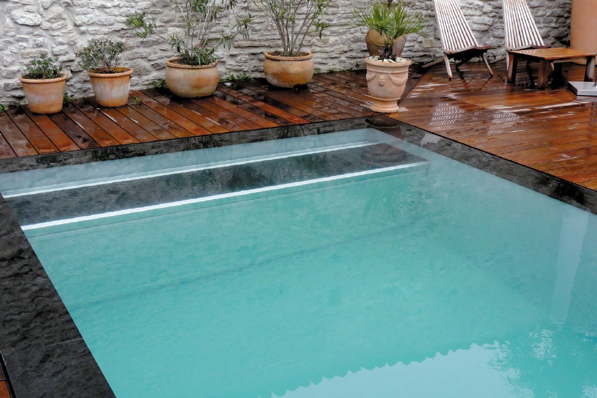 Piscine avec eau claire et système de volet.