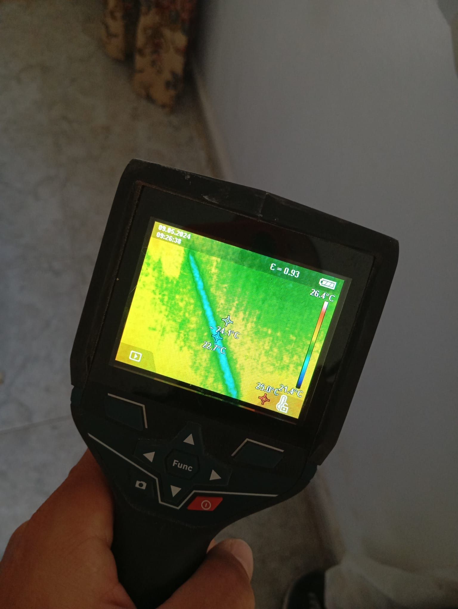 Una persona sostiene una cámara térmica con una pantalla amarilla.