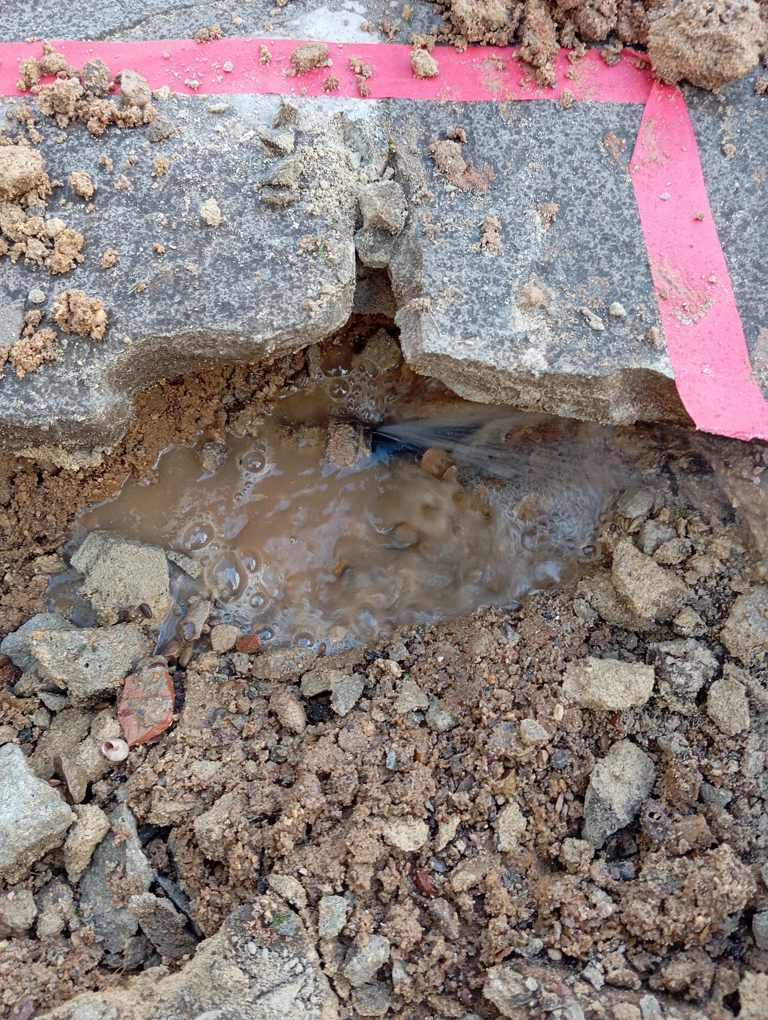 Un agujero en el suelo del que sale agua.