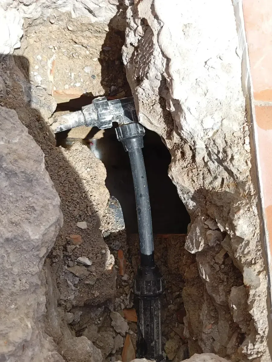 Conexión de una tubería de fontanería dentro de un agujero en una pared de hormigón