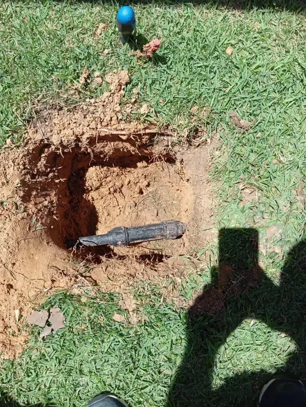 Un agujero excavado en la hierba dejaba al descubierto una tubería subterránea oscura