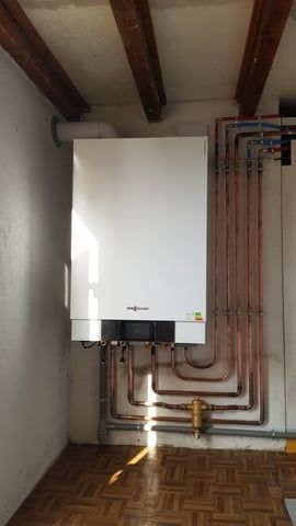 chaudière avec une façade blanche et tuyauterie en cuivre