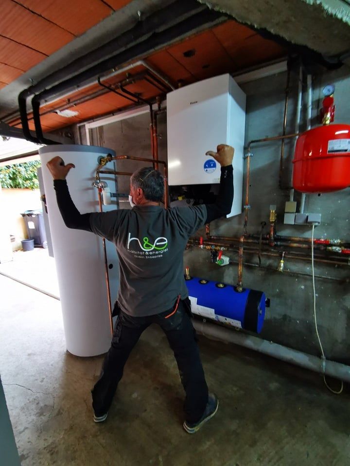 employé montrant son t-shirt devant un ballon d'eau chaude juste installé