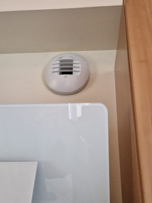 bouche d'aération arrondie sur un mur beige