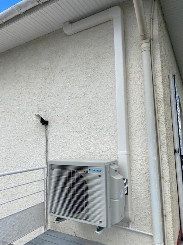 unité extérieure disposée contre un mur crépi