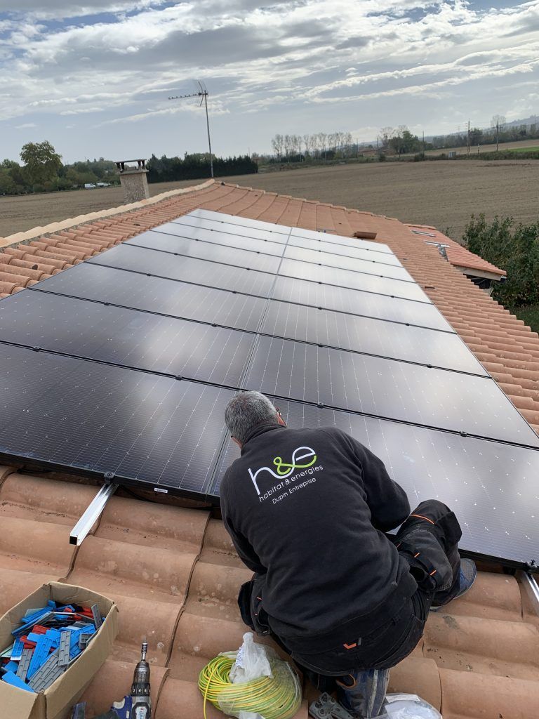 employé en train de fixer des panneaux photovoltaïques 