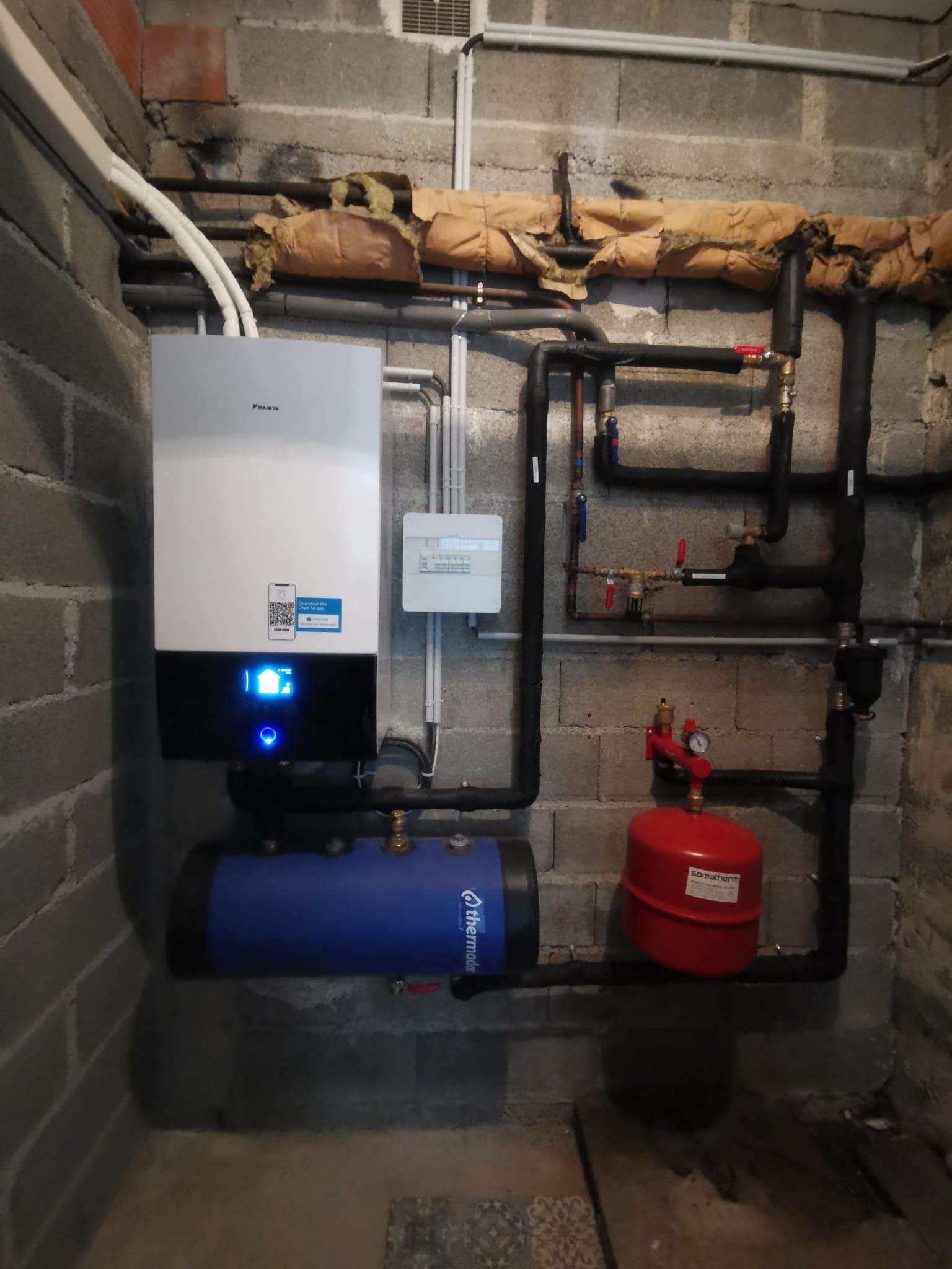 pompe à chaleur air eau de la marque Daikin installée contre un mur brut à Toulouse