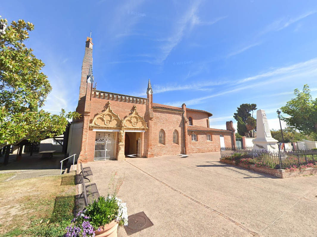 Église avec façade en briques rouges, fenêtres cintrées et haut clocher sous un ciel bleu.