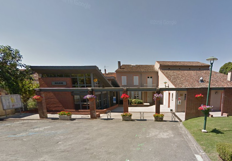 Bâtiment de la mairie avec façade en briques, bacs à fleurs et entrée vitrée.