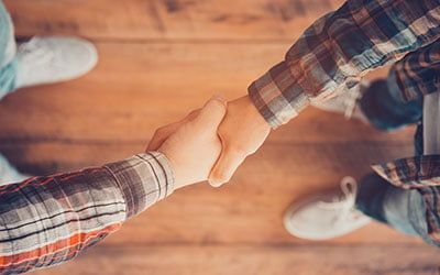 deux personnes se serrant la main vue du dessus