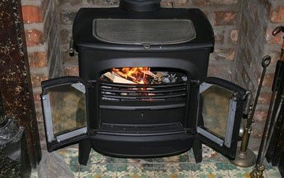 poele à bois noir incrusté dans une cheminée