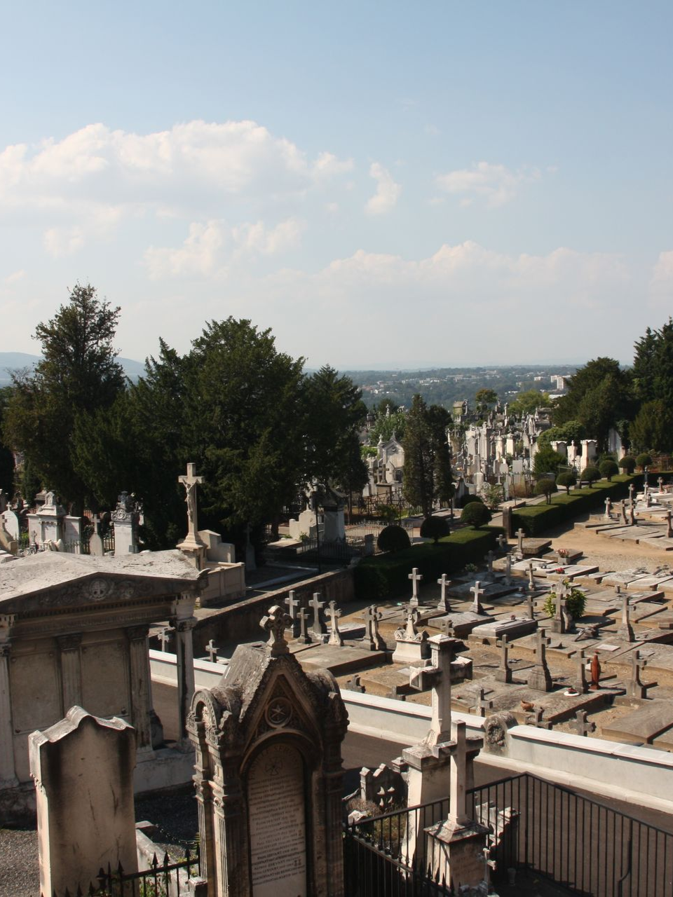 Cimetière avec des rangées de pierres tombales et de monuments sous un ciel d'un bleu éclatant