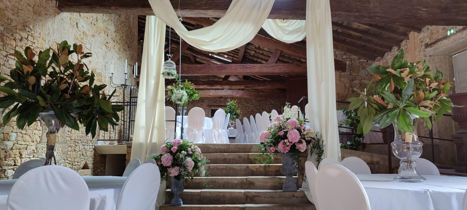 Décoration de cérémonie de mariage avec draperies, compositions florales et chaises blanches sur une estrade d'escalier