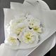 Bouquet de fleurs blanches enveloppées dans du papier blanc sur fond gris