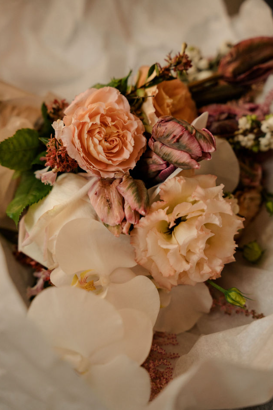 Bouquet de fleurs pêche et crème avec des roses et des pétales blancs délicats