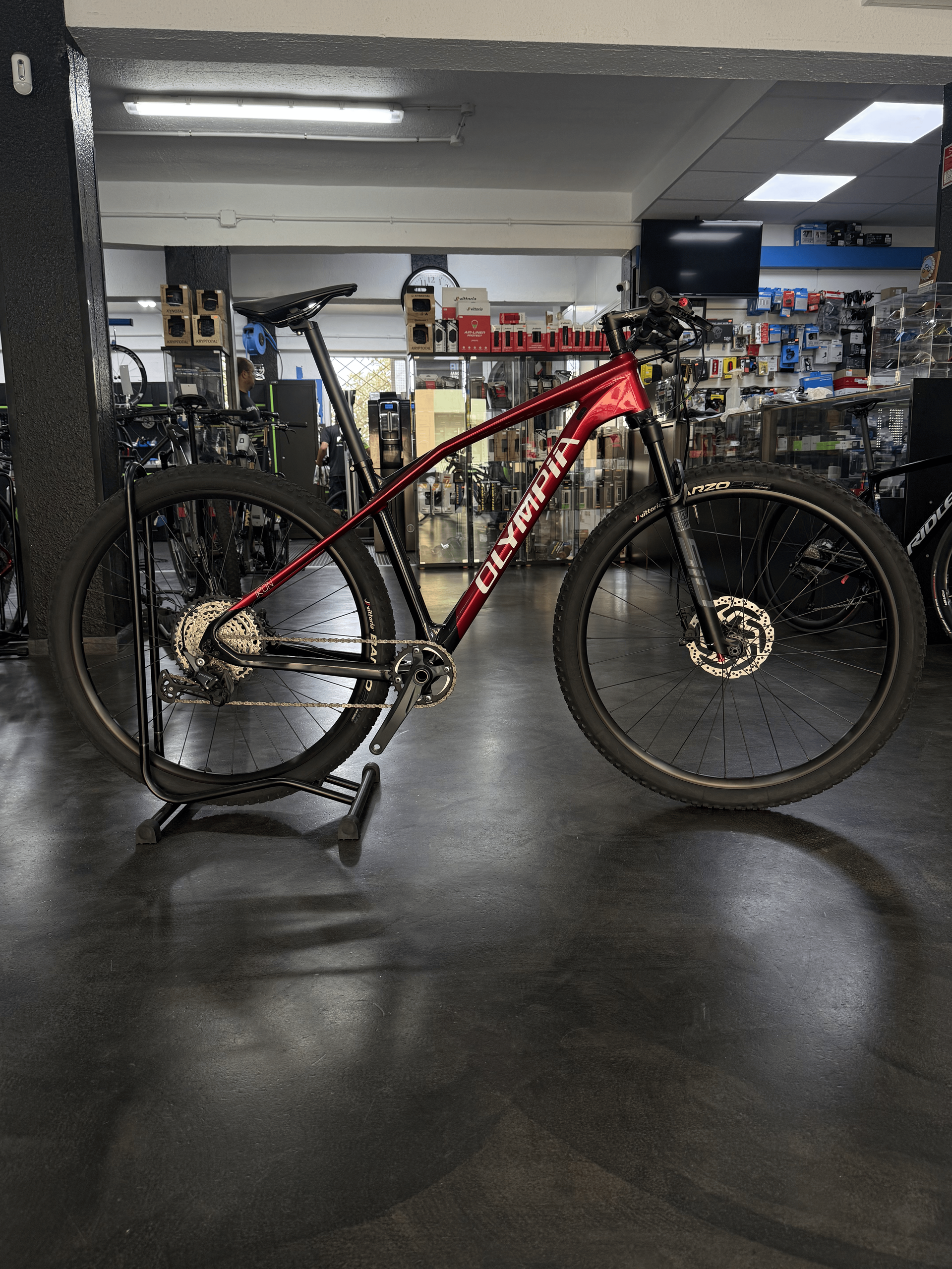 Bicicleta de montaña roja expuesta en el interior de la sala de exposición de una tienda de bicicletas.