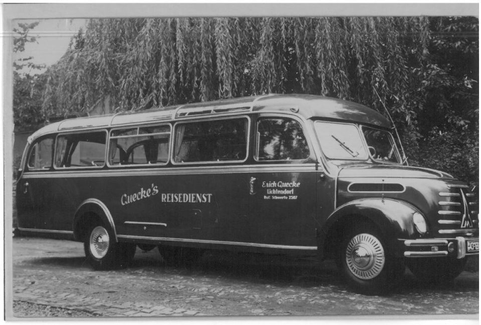 Ein Schwarzweißfoto eines Busses mit der Aufschrift „Cander's Reisedienst“ auf der Seite