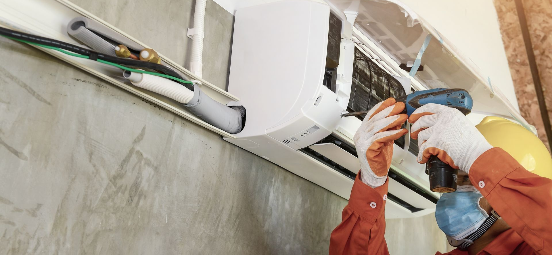 Un homme réparant un climatiseur