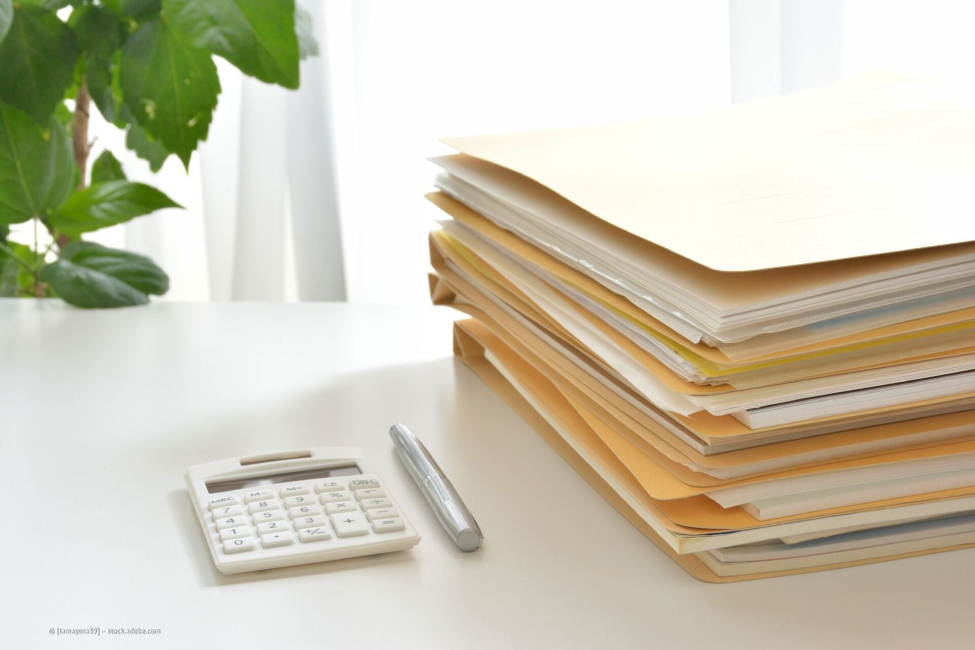 Tisch mit Akten und Taschenrechner