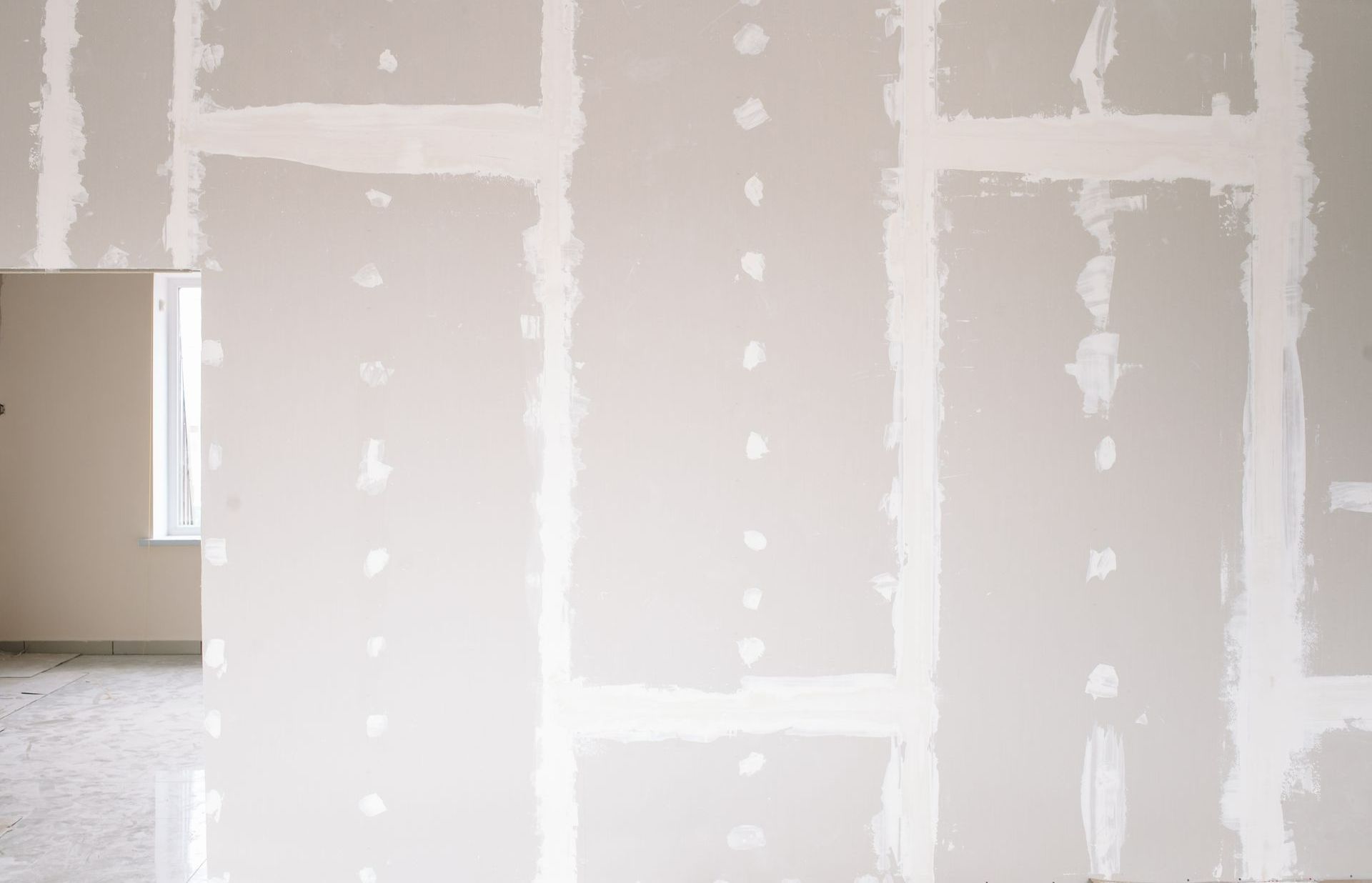 Une pièce avec des murs où ont été posées des bandes de joints