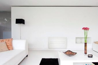 Una sala de estar con un sofá blanco y una mesa blanca.