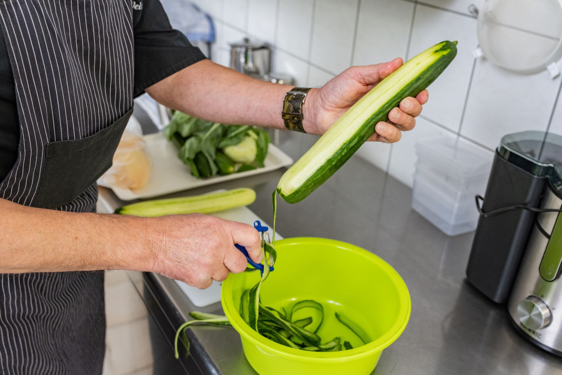 Ein Mitarbeiter von Hygiene Schröder schält eine Gurke