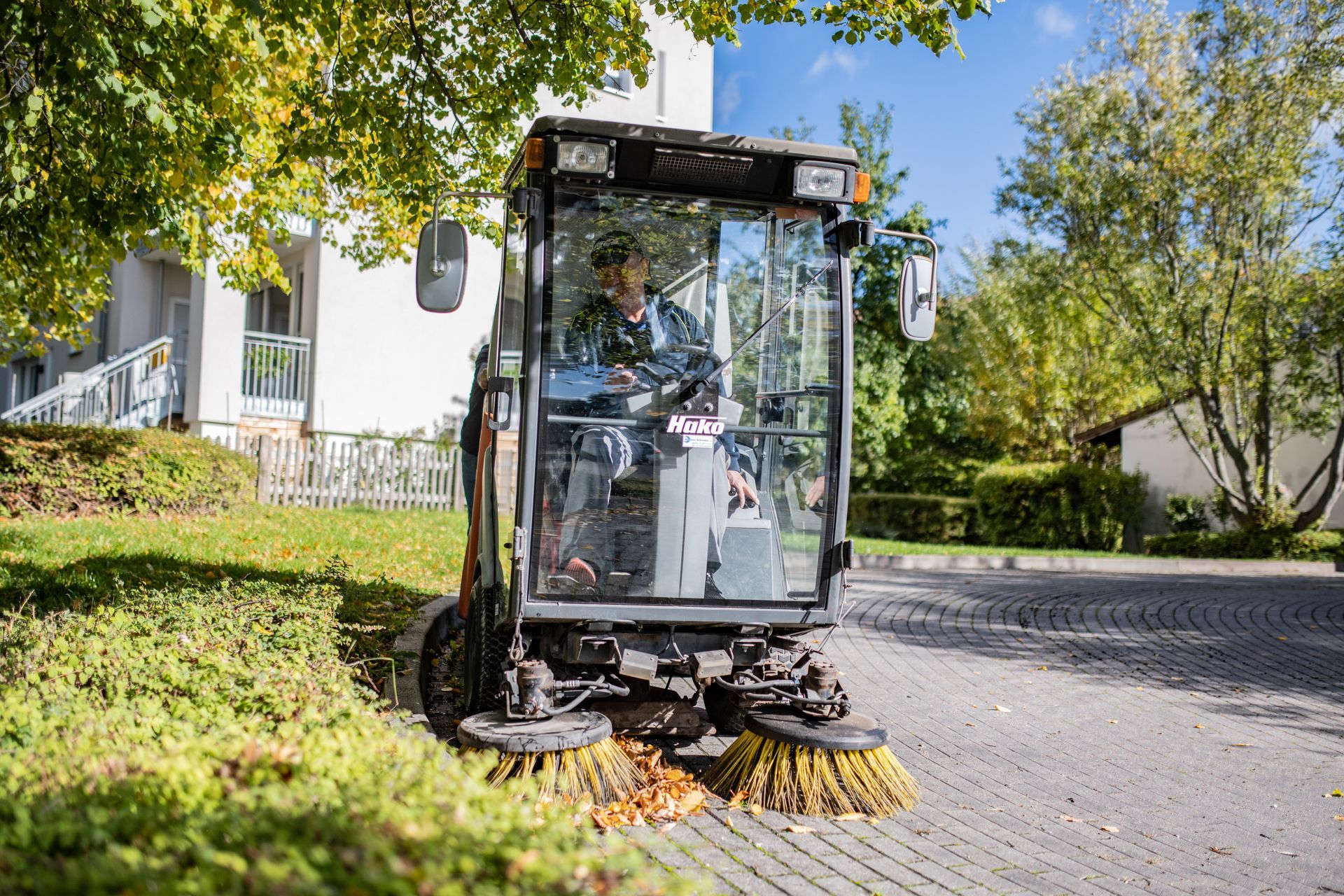 Ein Mitarbeiter von Hygiene Schröder sitzt in einer Kehrmaschine