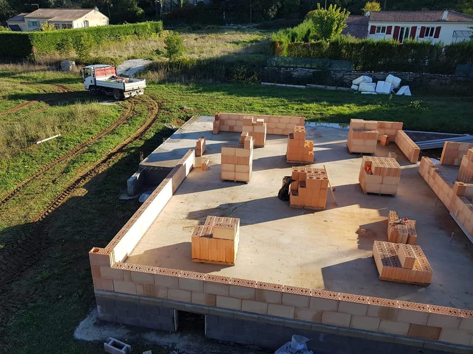 Fondations d'une maison et début de murs en brique.