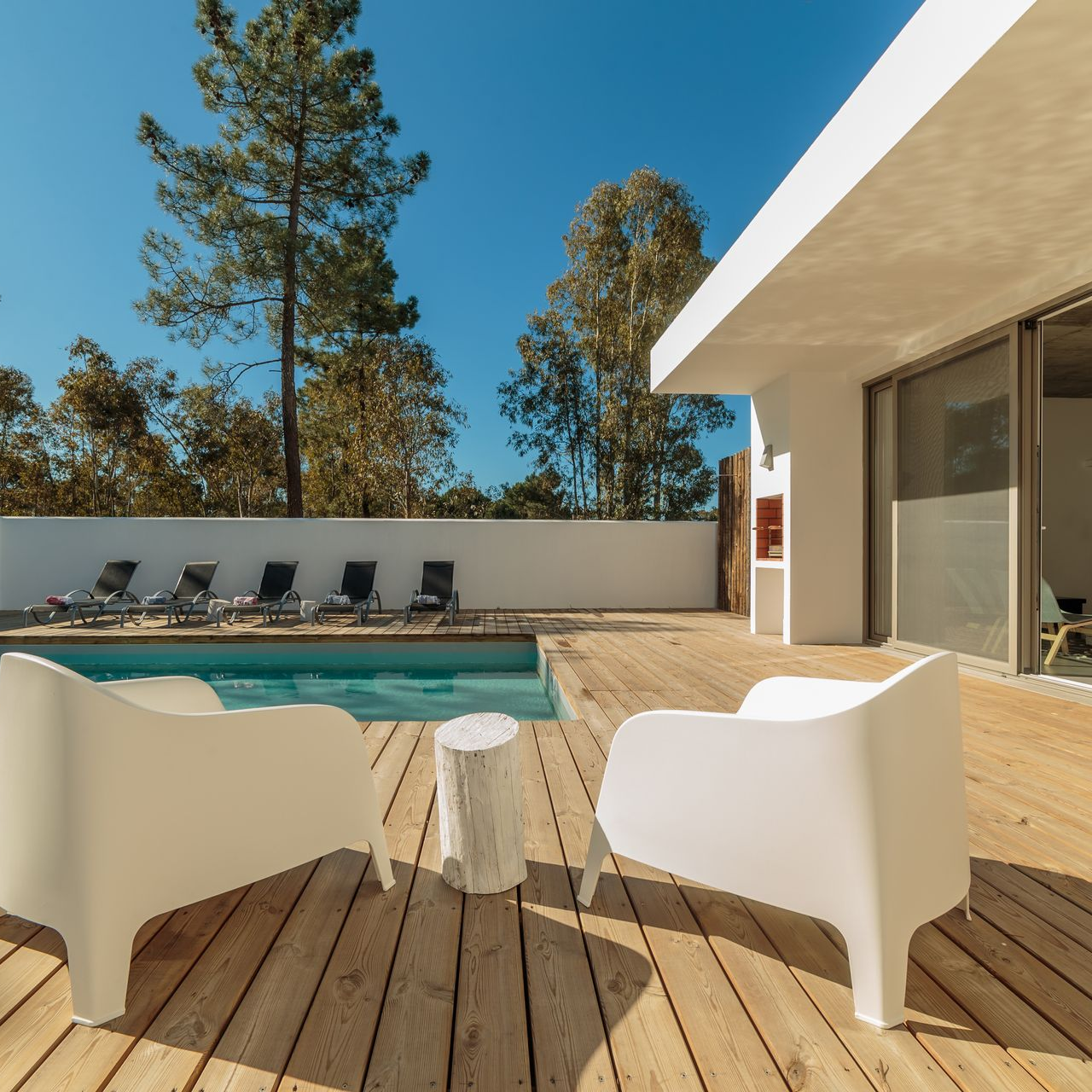 Terrasse en bois autour d'une piscine.