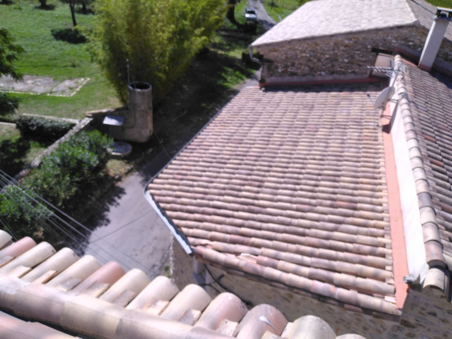 Plusieurs pans de toiture en tuiles romanes.