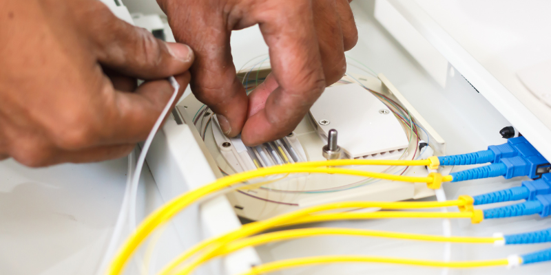 Une personne travaille sur un séparateur de fibre optique.