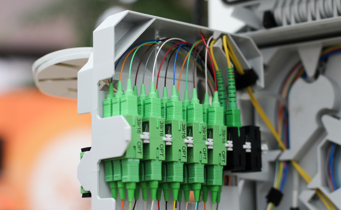 Une personne installe un câble à fibre optique dans une boîte.