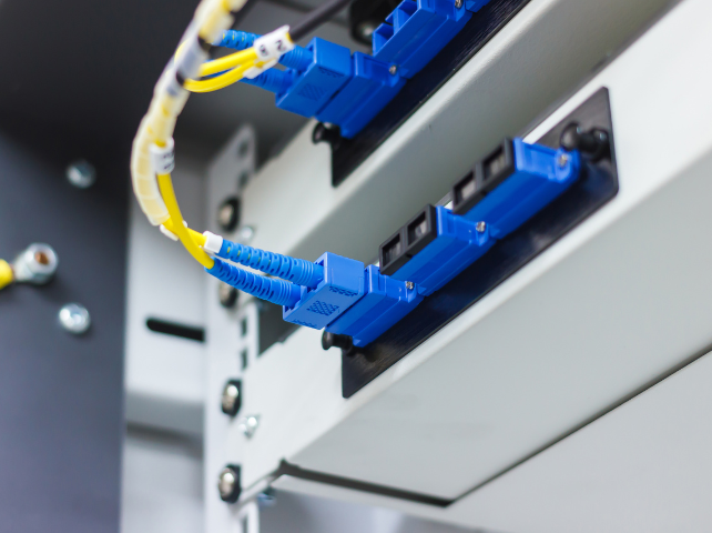 Un routeur noir est posé sur une table blanche.