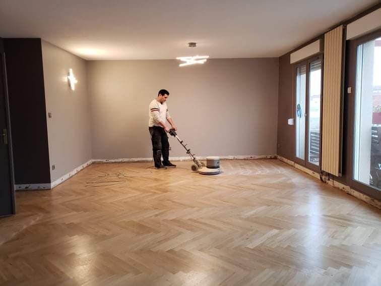 Professionnel qui ponce un parquet