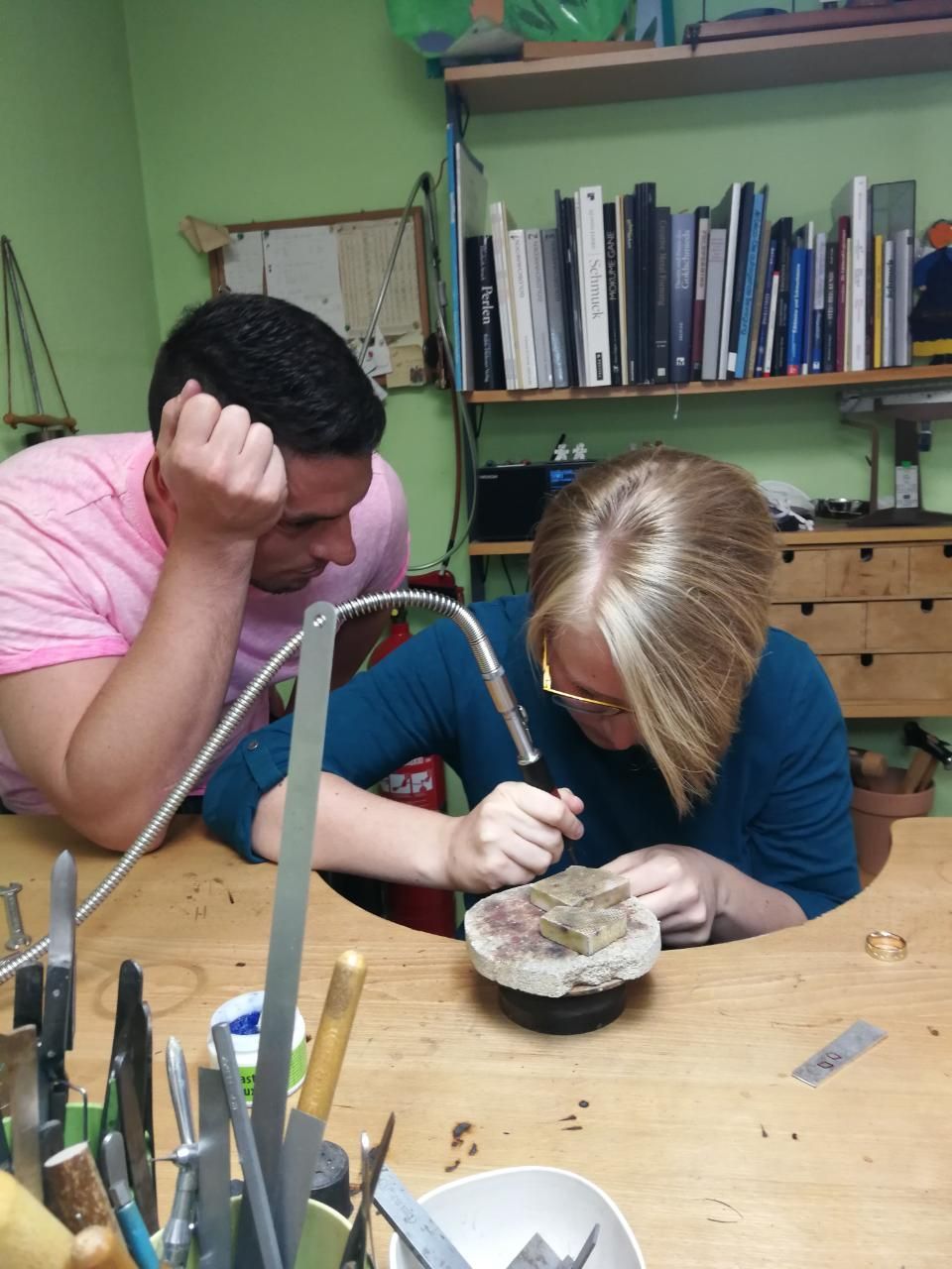 AF Goldschmiede, Frau bearbeitet Schmuckstück, Mann schaut zu