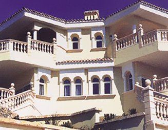 Una gran casa blanca con un cielo azul al fondo.