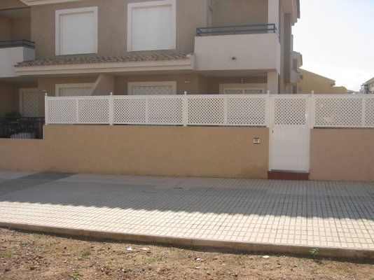Una casa con una cerca blanca y una puerta blanca