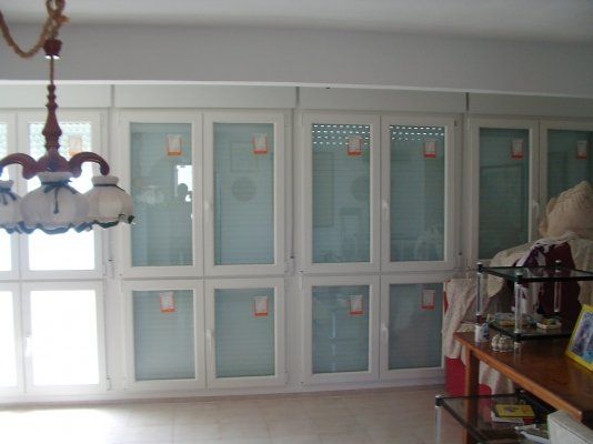 Una habitación con muchas puertas de vidrio y una lámpara de araña colgando del techo.