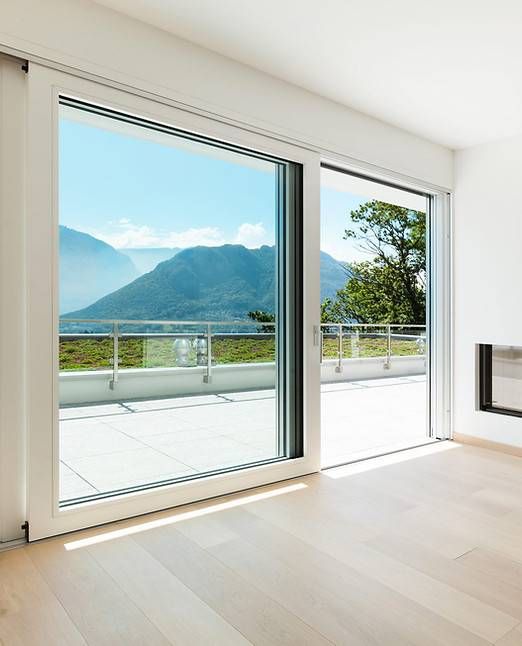 Helles Zimmer mit offenen Glasschiebetüren, Balkon und malerischem Bergblick.