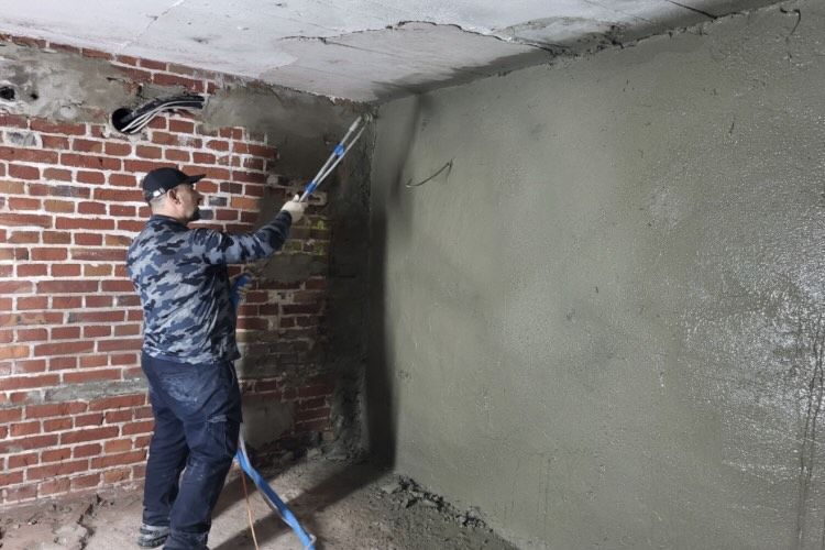 Mann arbeitet an einer Wand und führt and dieser eine Isokristall Abdichtung durch. 
