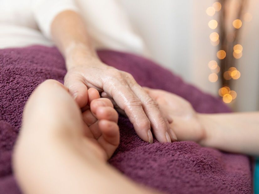 Una persona sostiene suavemente la mano de otra que descansa sobre