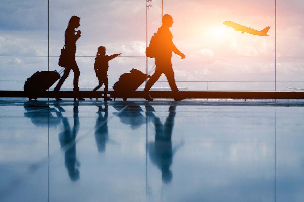 Silhouettes d'une femme, un enfant et un homme dans un aéroport