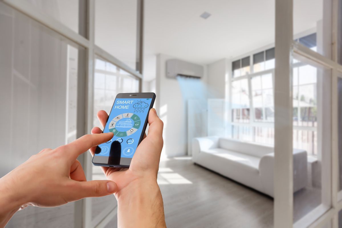 Canalones de metal marrón a lo largo del borde de un techo, con una pared de ladrillo debajo y fondo borroso.