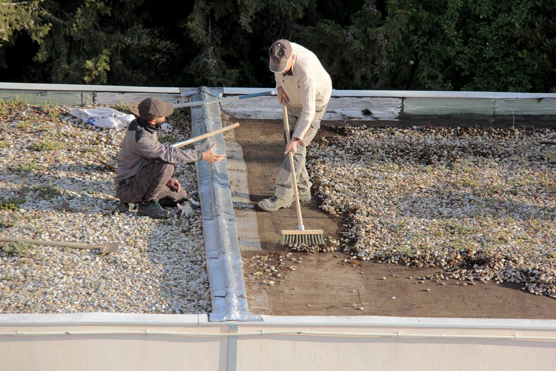 Deux couvreurs pendant l’entretien d’une toiture plate