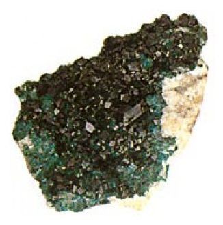 Un primer plano de una roca negra y verde sobre un fondo blanco.